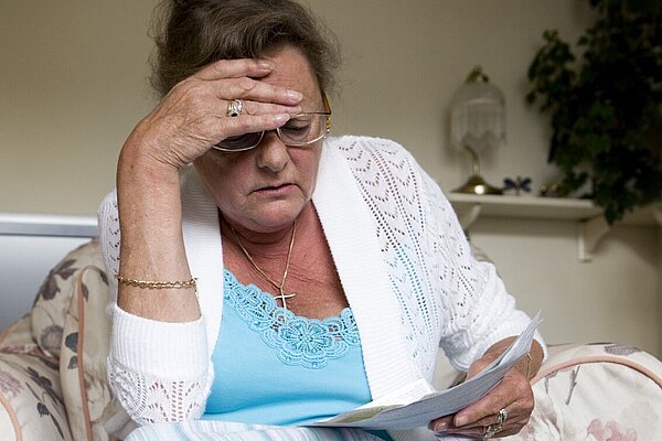 A lady looking at her bills.